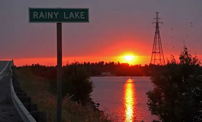 rainy lake street sign with sunset